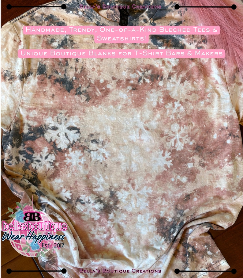 May include: A beige, brown, and black bleached t-shirt with a snowflake pattern. The shirt has text that reads "HANDMADE, TRENDY, ONE-OF-A-KIND BLEACHED TEES & SWEATSHIRTS!" and "UNIQUE BOUTIQUE BLANKS FOR T-SHIRT BARS & MAKERS".