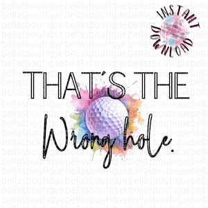 May include: A watercolor design with a golf ball in the center. The text "THAT'S THE Wrong hole." is written in black cursive.