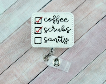 Könnte beinhalten: Weißer Badge-Halter mit einem weißen quadratischen Patch, auf dem in schwarzer Kursivschrift "coffee", "scrubs" und "sanity" steht. Die Wörter stehen auf einer Checkliste mit roten Häkchen neben "coffee" und "scrubs".