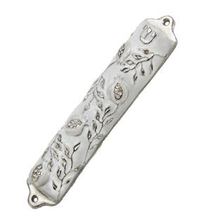 May include: White mezuzah with silver detailing of pomegranates and vines. The mezuzah has a silver Hebrew letter Shin on the top.