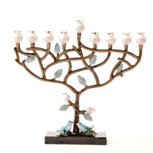 May include: A menorah shaped like a tree with pink flowers and blue birds. The menorah is made of metal and has a brown finish.