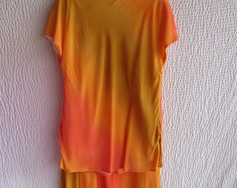 May include: A two-piece outfit with a short-sleeved top and a skirt. The top and skirt are a gradient of orange and yellow.