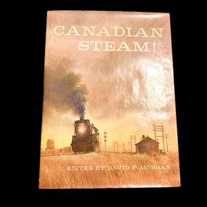 May include: A vintage book cover with a brown background and the title "CANADIAN STEAM!" in white text. The cover features a watercolour illustration of a steam locomotive pulling a train through a rural landscape. The text "EDITED BY DAVID P. MORGAN" is printed in white at the bottom of the cover.