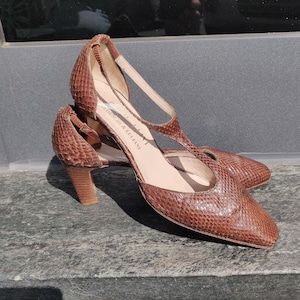 Op de afbeelding: Bruine leren hakken met een slangenhuidpatroon en een T-band. De schoenen hebben een merklabel met de tekst "F.lli  Fieschi & Lugnani".