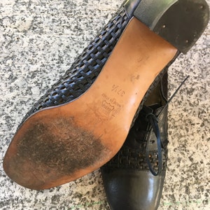 Puede incluir: Zapatos de cuero negro con un dise&ntilde;o tejido y un tac&oacute;n bajo. Los zapatos est&aacute;n hechos en Italia y tienen una talla de 37 1/2.
