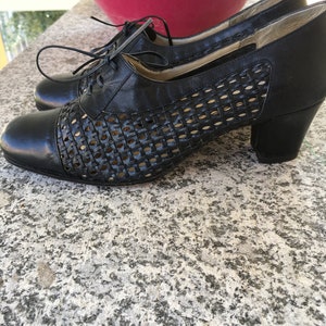 Puede incluir: Zapatos de cuero negro con un dise&ntilde;o tejido y un tac&oacute;n de bloque. Los zapatos tienen un cierre de encaje.