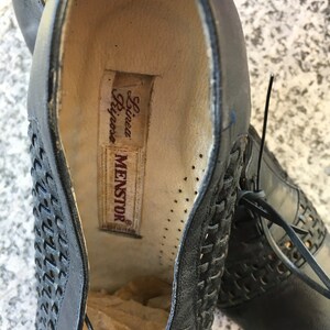 Puede incluir: Primer plano del interior de un zapato de cuero negro con un patr&oacute;n tejido. El zapato est&aacute; etiquetado con "Menstor" y "Linea Rigore".