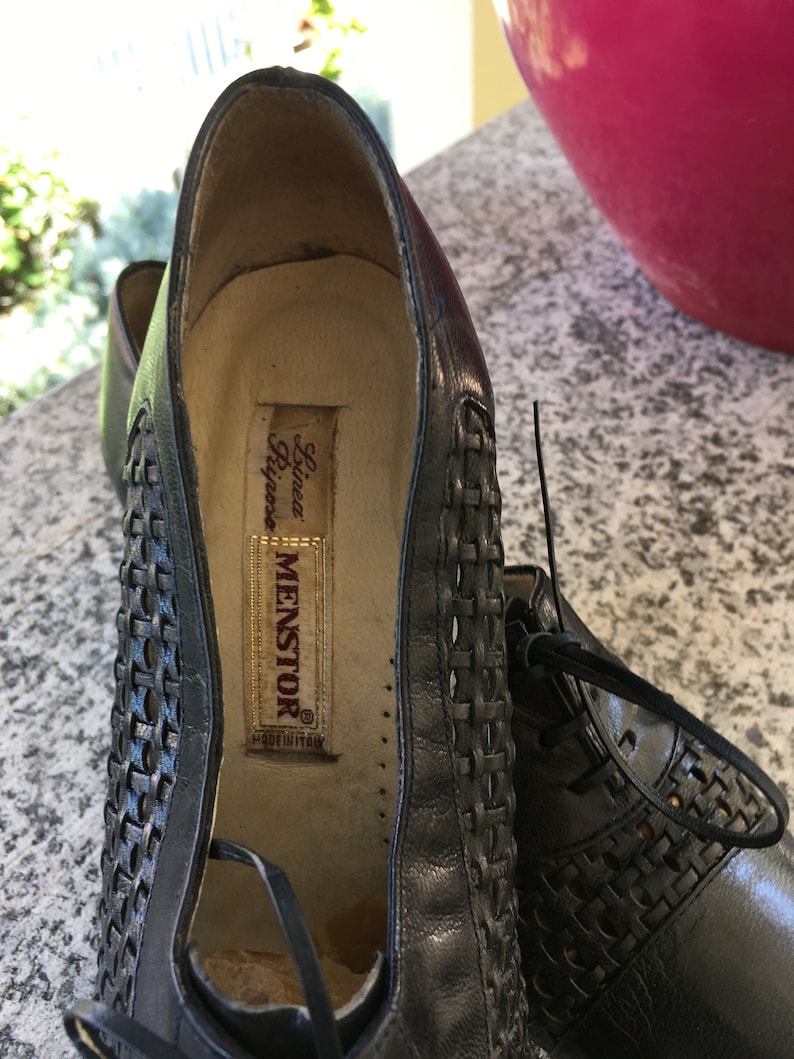 Puede incluir: Zapatos de cuero negro con un dise&ntilde;o tejido y una etiqueta que dice "Linea Riposo Menstor Made in Italy."