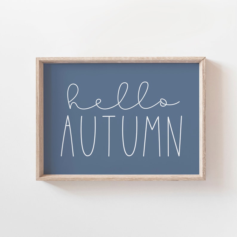May include: A framed print with the text "hello autumn" in white script on a blue background.