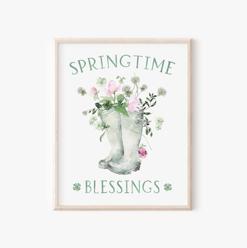 May include: A watercolor illustration of a pair of green rain boots filled with pink and white flowers. The text "SPRINGTIME BLESSINGS" is written in green below the boots.