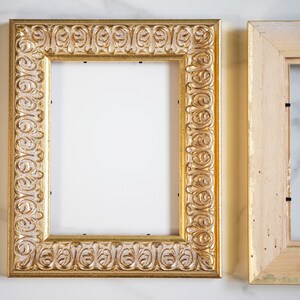 May include: Two ornate picture frames, one with a gold finish and intricate carvings, and the other with a natural wood finish. Both frames are empty.