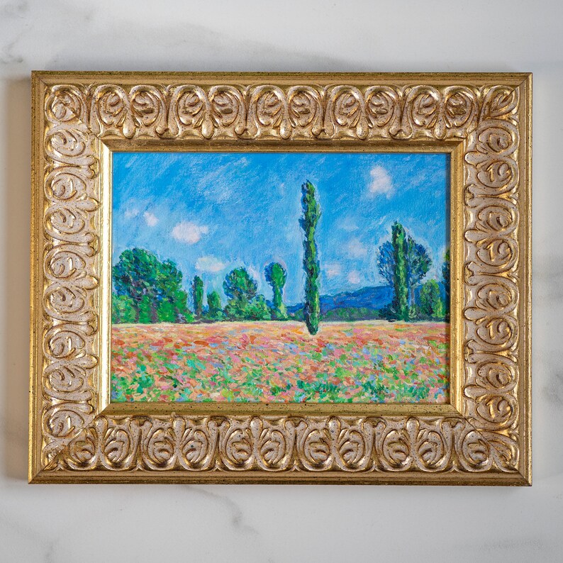 May include: A framed painting of a landscape with a field of flowers and a row of trees in the background. The sky is blue with white clouds. The frame is gold with an ornate design.