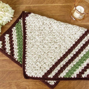 May include: A crocheted throw blanket with a brown, green, and white striped pattern. The blanket is folded in half and has a fringe border.