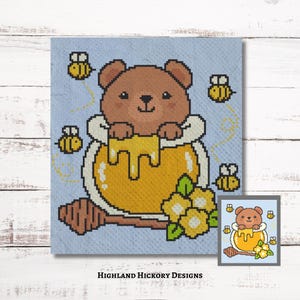 Puede incluir: Diseño de punto de cruz con un oso pardo en un tarro de miel con miel goteando. Abejas amarillas vuelan alrededor del oso y del tarro de miel. También se incluyen flores amarillas y un cucharón de miel. El texto "HIGHLAND HICKORY DESIGNS" está en la parte inferior.