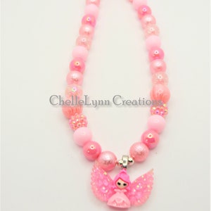 May include: Pink beaded necklace with a pink angel charm. The necklace is made with iridescent beads and a silver clasp.