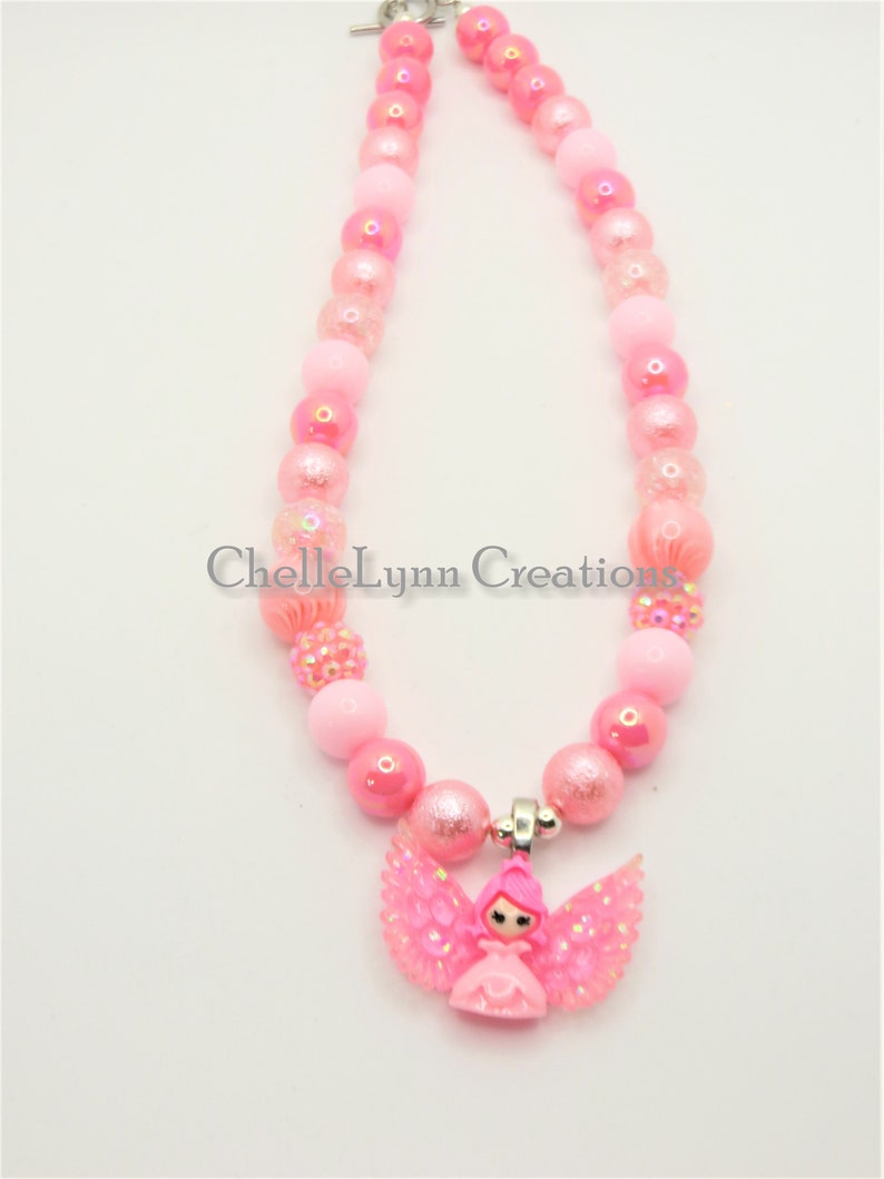 May include: Pink beaded necklace with a pink angel charm. The necklace is made with iridescent beads and a silver clasp.