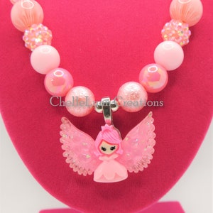 May include: Pink beaded necklace with a pink fairy charm. The necklace is made with iridescent and glitter beads.