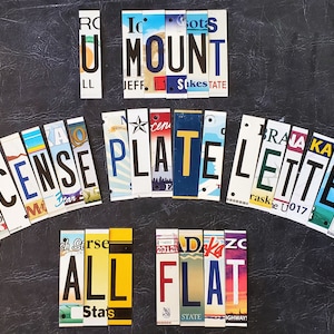 May include: A collection of license plates spelling out the words "LICENSE PLATE LETTERS ALL FLAT" in a variety of colors and designs.