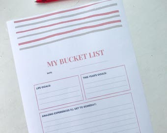 May include: A printable bucket list with sections for life goals, this year's goals, and amazing experiences to get to someday. The printable has a pink and gray striped design.