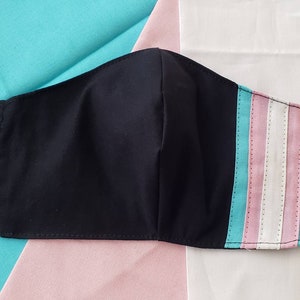 May include: Black face mask with a light blue, pink, and white stripe pattern on the right side.