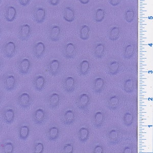 Puede incluir: Primer plano de una tela morada con un patrón texturizado de pequeños círculos. La tela es suave y afelpada, perfecta para proyectos de manualidades o costura.