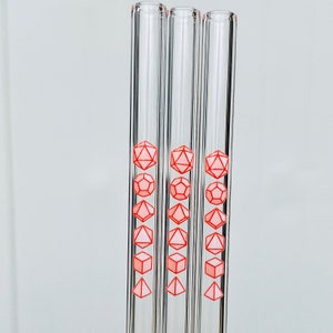 Pu&ograve; includere: Set di tre cannucce da bere in vetro con disegni di dadi rosa stampati su di esse.
