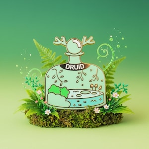Peut inclure: Épingle en émail vert menthe en forme de bouteille avec le mot "DRUID". L'épingle représente une scène de forêt avec un lac, des arbres et des champignons. L'épingle est entourée de mousse, de fougères et de petites fleurs.