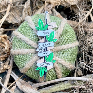 May include: A silver sword with green leaves and a white banner that reads "You Have My Sword".