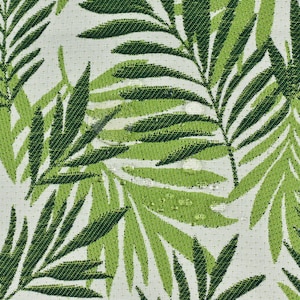 May include: A white fabric with a green palm leaf pattern. The leaves are a dark green and light green colour.