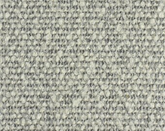 Op de afbeelding: Close-up van een lichtgrijze, textuurrijke stof met een licht hobbelige oppervlak.