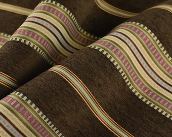 May include: Close-up of brown fabric with wavy, vertical stripes. The stripes feature a repeating pattern of light beige, pink, green, and gold. The fabric is folded, showing the texture and depth of the material.