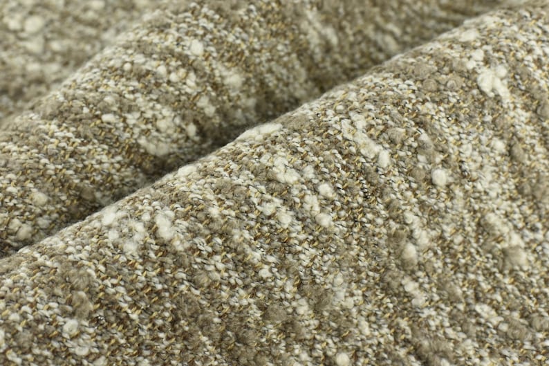 May include: Close-up of a textured fabric with a brown and white speckled pattern. The fabric has a soft, fuzzy texture.