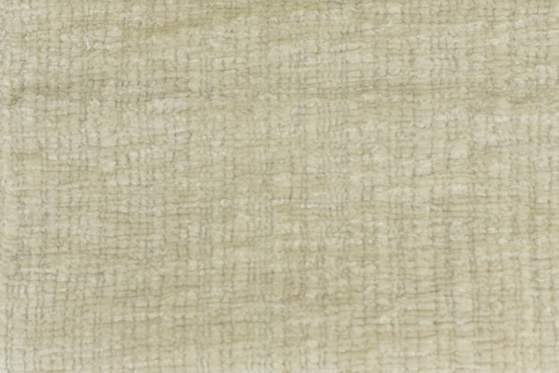 May include: A close-up of a beige textured fabric with a woven pattern.