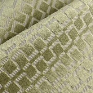 May include: A sage green fabric featuring a raised, velvet-like geometric square pattern. The design consists of repeating squares arranged in a grid, set against a lighter, finely ribbed background texture that creates a distinct depth and contrast.