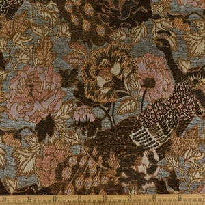 K&ouml;nnte beinhalten: Brauner und rosa Bl&uuml;mchenstoff mit einem sich wiederholenden Muster aus Pfauen und Blumen. Der Stoff hat eine strukturierte, gewebte Optik.
