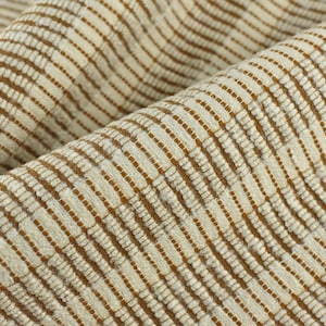 May include: Close-up of a textured fabric with a repeating pattern of vertical stripes. The stripes alternate between a light beige and a darker brown color, creating a subtle contrast. The fabric appears to be woven.