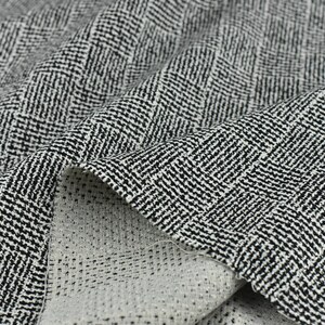 May include: Black and white herringbone patterned fabric with a subtle texture. The fabric is folded over, showing the reverse side.