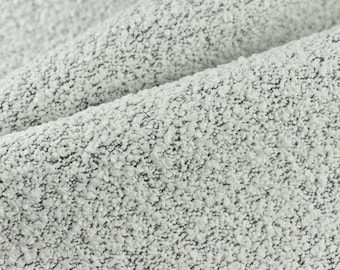 May include: Close-up of a white and gray textured fabric with a slightly bumpy surface.