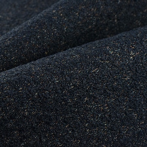 Può includere: Primo piano di un tessuto blu navy strutturato con sottili macchie d'oro e altri colori. Il tessuto è piegato, mostrando la profondità e la consistenza del materiale. Questo tessuto potrebbe essere utilizzato per tappezzeria o abbigliamento.