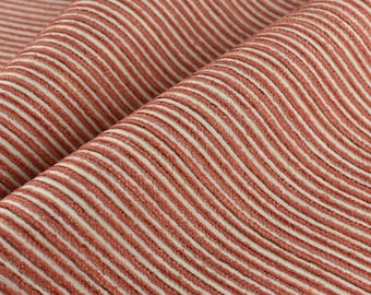 May include: Close-up of a red and white striped fabric with a textured, woven pattern.