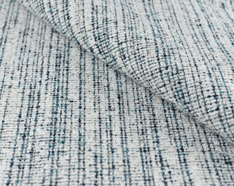 May include: Close-up of a textured fabric with a white background and blue and grey threads woven together.