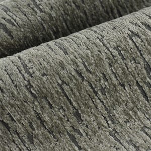 May include: Close-up of a textured fabric in a grey and green colour scheme. The fabric has a subtle striped pattern and a slightly rough texture.