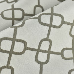 May include: White fabric with a repeating pattern of brown interlocking ovals.