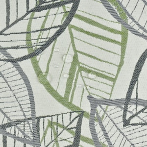 Könnte beinhalten: Ein weißer Stoff mit einem sich wiederholenden Muster aus grünen und grauen Blättern. Die Blätter sind stilisiert und haben eine gewebte Textur.