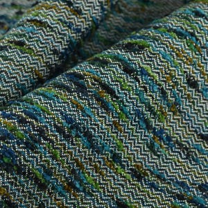 Puede incluir: Primer plano de una tela con estampado azul, verde y plateado con diseño de chevron.