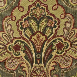 May include: Close-up of a decorative fabric with a detailed paisley pattern. The design features a central medallion with floral and scroll motifs in shades of olive green, burgundy, and gold against a dark green background.