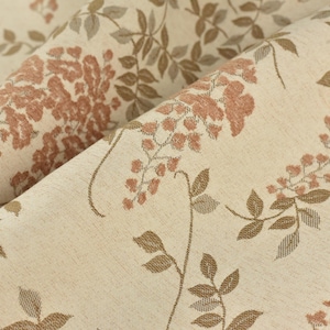Puede incluir: Primer plano de una tela beige con un estampado floral. El diseño presenta racimos en cascada de flores de color marrón rojizo y hojas y tallos marrones detallados. La tela está doblada, mostrando textura y profundidad.