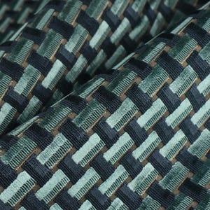 May include: A fabric featuring a woven basket-weave pattern in shades of dark navy, forest green, and light sage green. The texture consists of raised, rectangular segments arranged in a repeating grid, creating a dimensional surface appearance.
