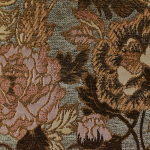 K&ouml;nnte beinhalten: Nahaufnahme eines Stoffes mit Blumenmuster. Der Stoff hat eine braune, rosa und beige Farbgebung. Die Blumen sind stilisiert und haben eine strukturierte Oberfl&auml;che.