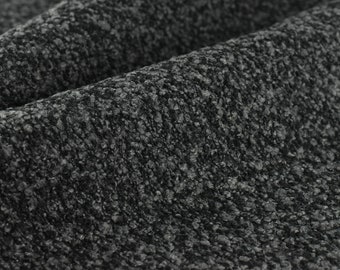 May include: Close-up of a dark gray textured fabric with a slightly rough surface.